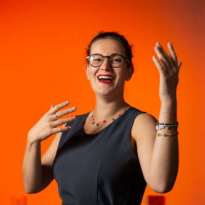 Digital Media and Interaction Design student, Rachele Cavina, in front of an orange backdrop
