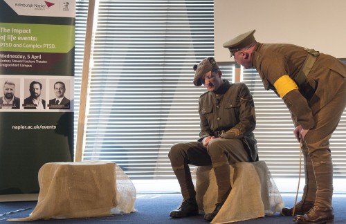 Army officer screaming into the face of a disgruntled man that is also dressed in an old army uniform sitting down