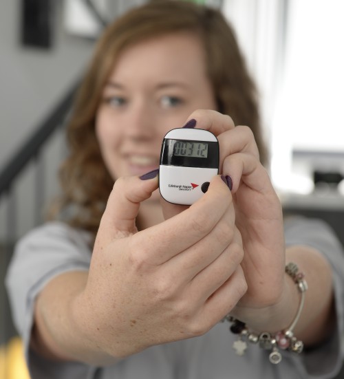 A woman holding a pedometer