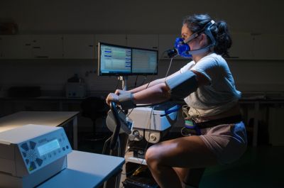 Image of a person on a stationary bike using sports technology equipment to monitor their performance