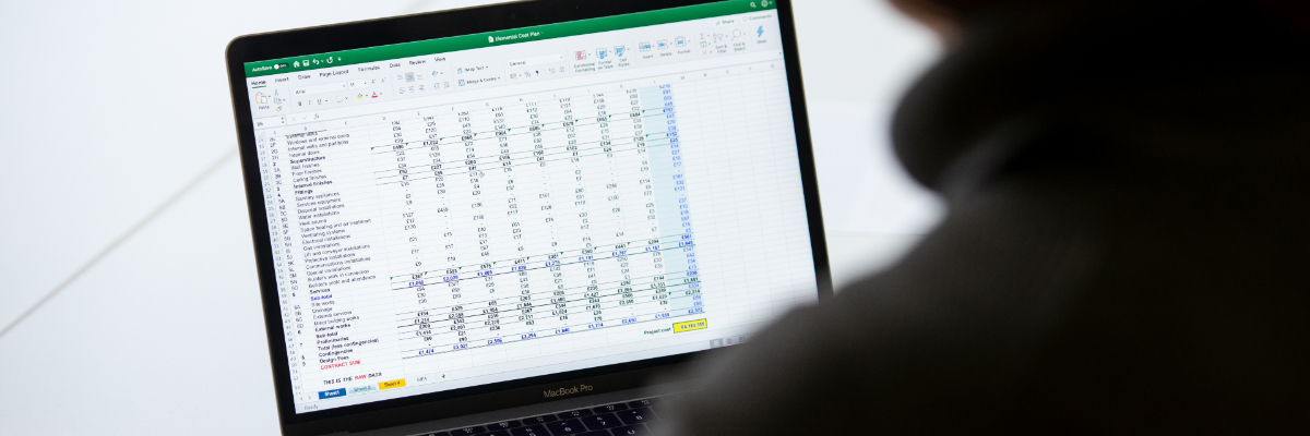 person sitting in front of a laptop that has a lot of data on its screen