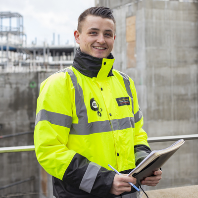 Evan Ramsay poses with a clipboard on a building site