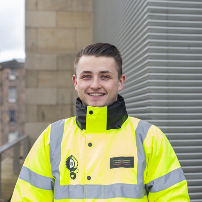 Quantity surveying student, Evan Ramsay, smiling in a high vis jacket.