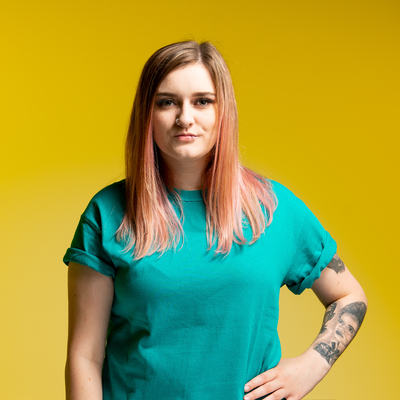 Sound design student, Alanah Walker, in front of a yellow backdrop