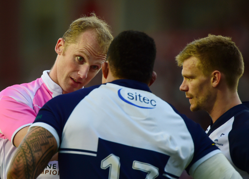 Referee talking to two sports players.