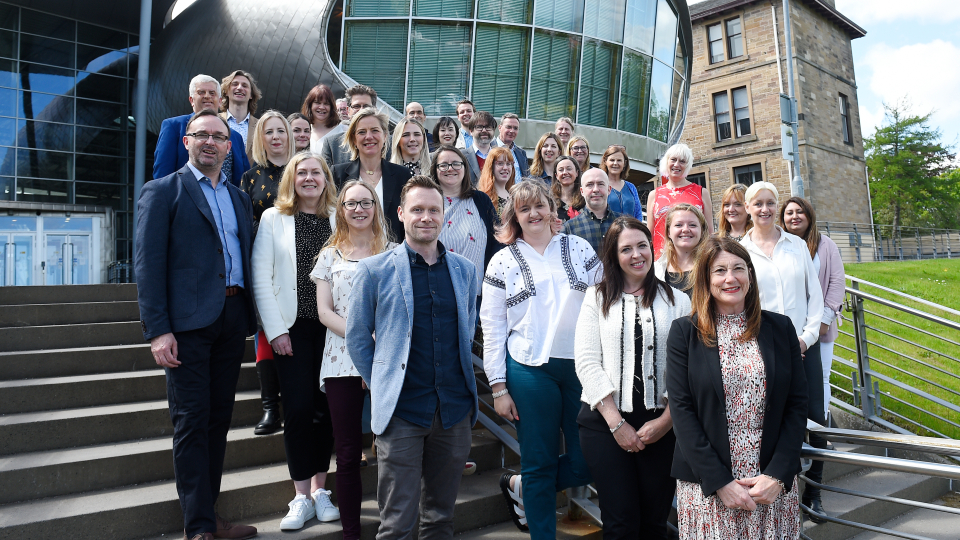 The DLP graduates standing in front of the Business School with Professor Jane Ali-Knight in the front