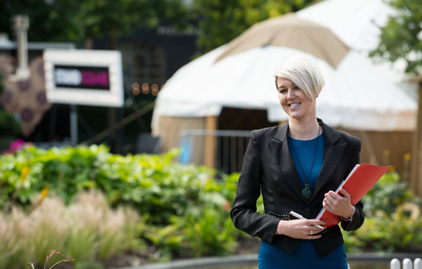 Student smiling as she walks through a decorated festival street