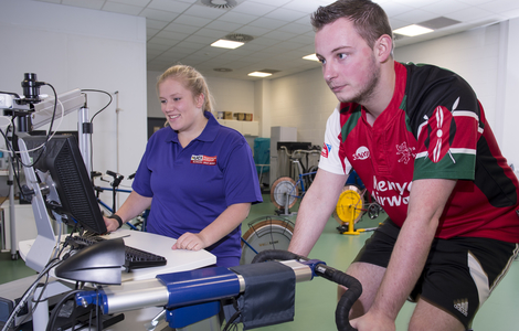 Staff and an athlete working with exercise bike in sports science lab