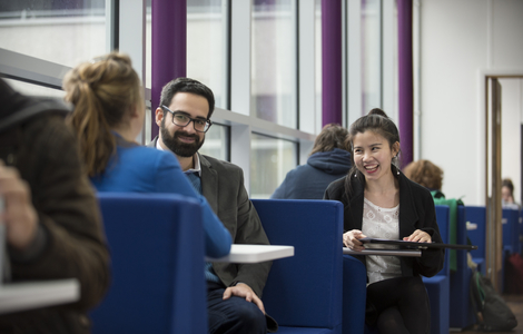 Students chatting and laughing whilst sitting at tables at merchiston entrance 