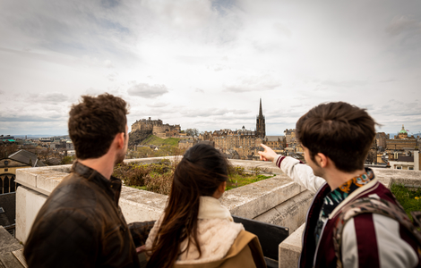 Students looking towards Edinburgh's landmarks from a rooftop