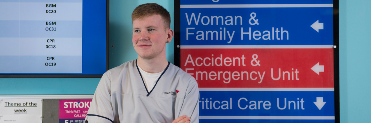 Male student nurse standing in a hospital
