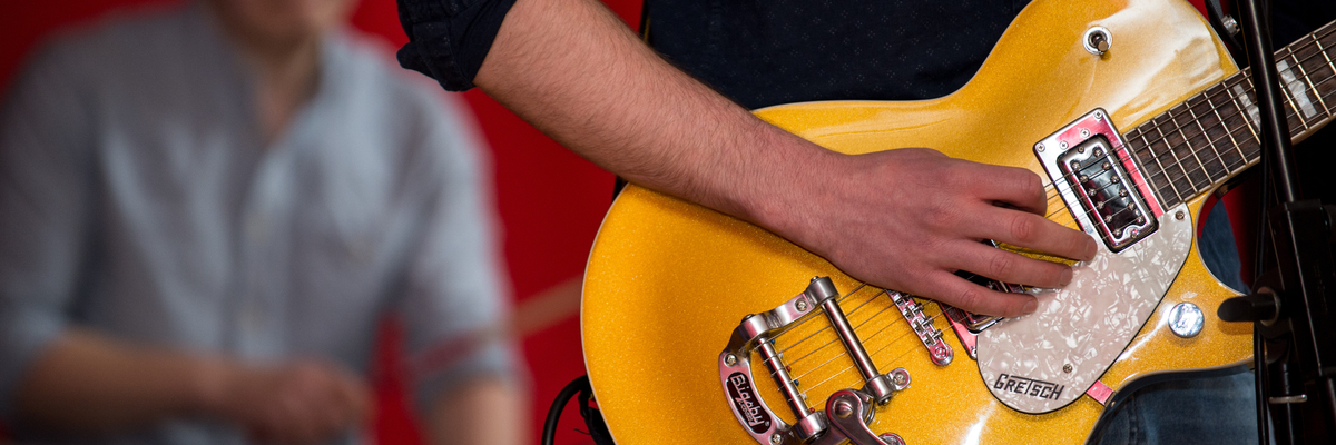 Close up of a persons hands playing the guitar 