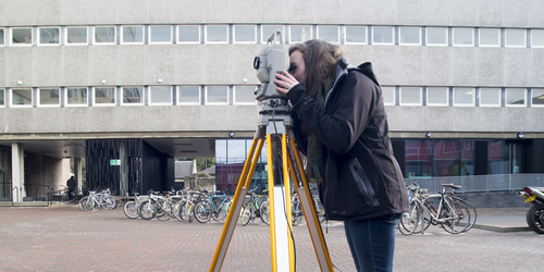 Student using surveying equipment in merchiston