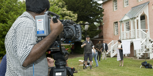 Man holding a camera to Film a scene at Craighouse campus