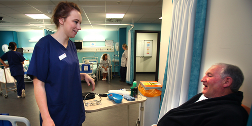 Nurse speaking to male patient in a 'ward' at the Clinical Skills and Simulation Centre at Edinburgh Napier University