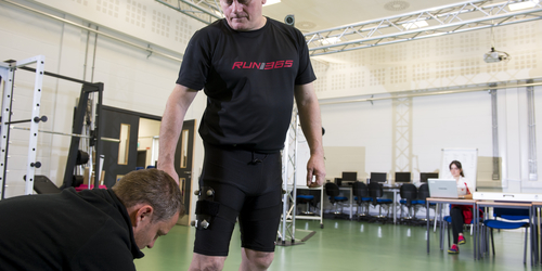 Fitness assessment with one man kneeling on the ground and another standing above him