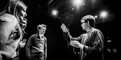 Students on stage chatting as they work on Shakespeare 