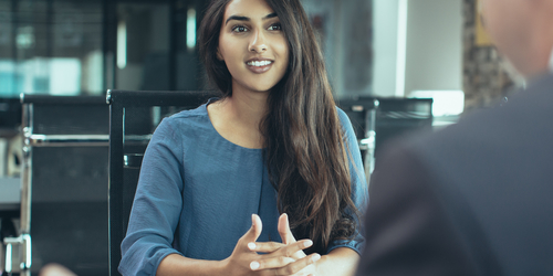 Lady sitting at a table opposite a man being interviewed