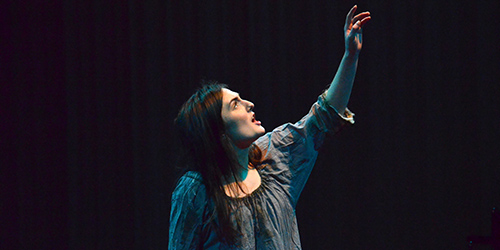 Edinburgh Napier student acting with their hand held up to the sky as they speak
