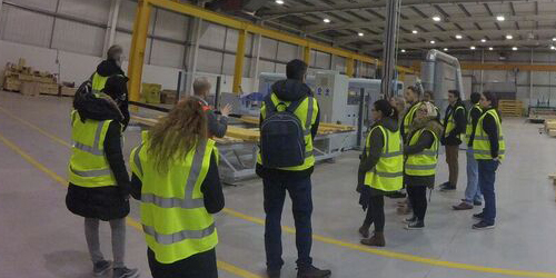 Students in high visibility vests visiting a construction company