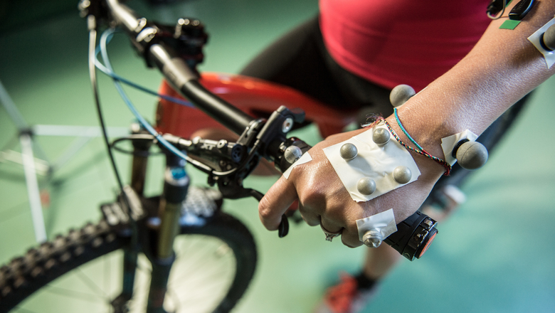 Close up of a persons hands on a mountain bike with motion sensors for research