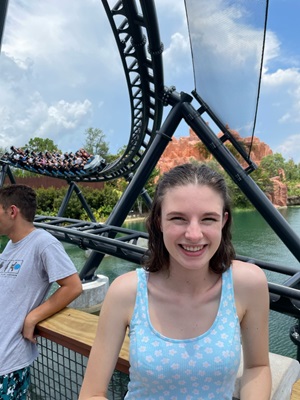 Iona standing in front of a roller coaster 