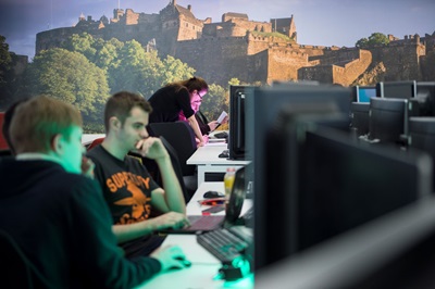A group of students in the university's computing lab, with a picture of Edinburgh castle on the wall