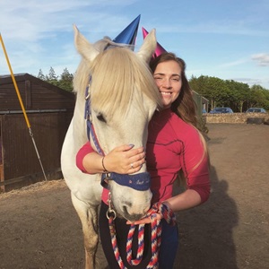 Lauren hugging a white horse