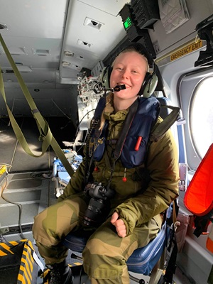 Maria wearing a camouflage jumpsuit sitting in rescue helicopter while serving in the Norwegian Armed Forces