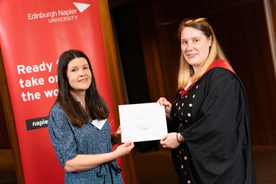 A person handing another person a certificate 
