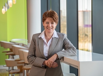 Janet Downie leaning against a high table