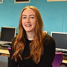 Toni Scullion sitting in front of computer screens