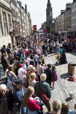A large crowd walking along the Royal Mile in Edinburgh