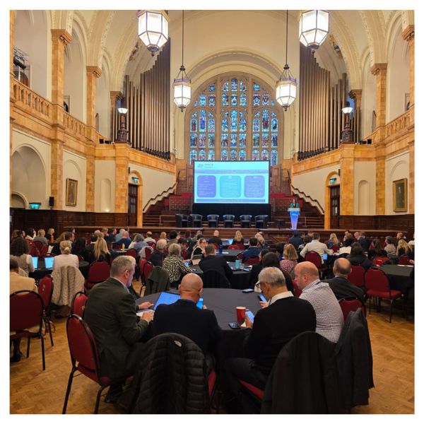 Attendees watching a SPACE talk in a large hall