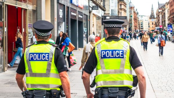 Two police officers walking down a busy street