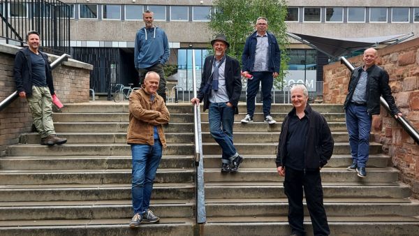 Industrial design reunion group standing on steps at Merchiston campus courtyard