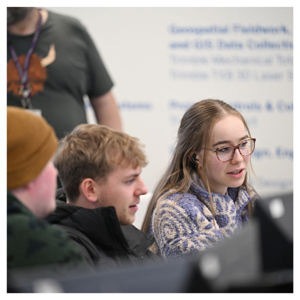 Three students working at a computer