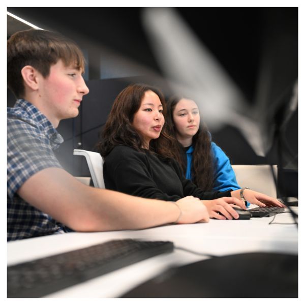 Three students working at a computer