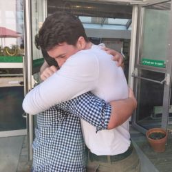 two alumni hugging at a reunion