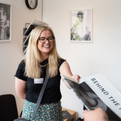 student handing out newspaper project