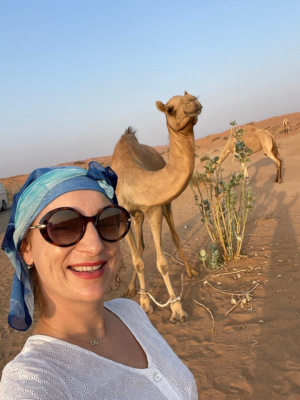Diana taking a selfie with a camel in the desert