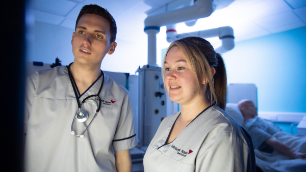 Healthcare students reviewing information in a clinical training room.