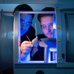 Two researchers working with laboratory equipment during an engineering research experiment