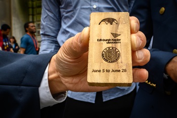 A student holding a bamboo tile memento