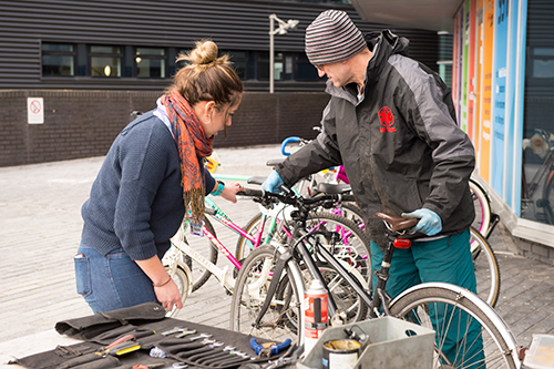 A student receives advice on her bike during a Dr Bike session at Sighthill
