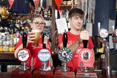 Edinburgh Napier students Ellie Devlin Stephen and Scott Stratford pouring a pint of the Must Be Napier beer