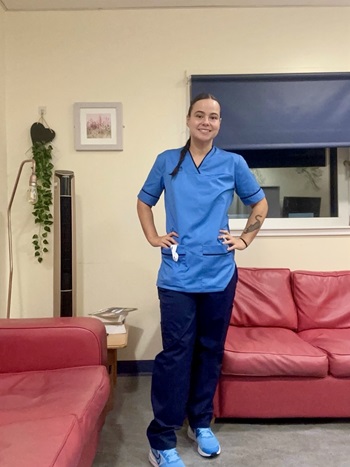 Caitlin Tervit standing in her nursing uniform