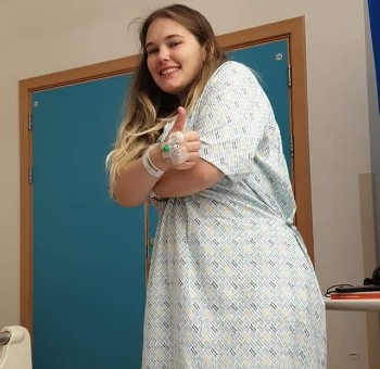 Hayley Kane in hospital clothing in a ward setting
