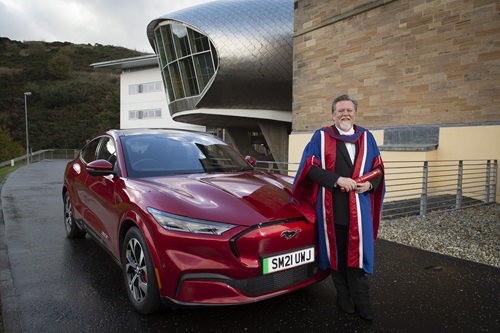 Honorary graduate Moray Callum with Ford Mustang Mach E 
