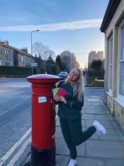 Student Rachel posts her prints to customers at a postbox in Edinburgh